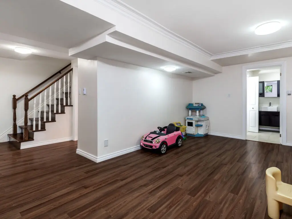 A finished basement with wood floors and white walls