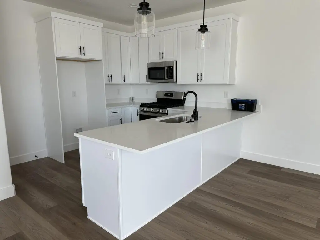 Kitchen with white countertops and cabinets with modern lighting