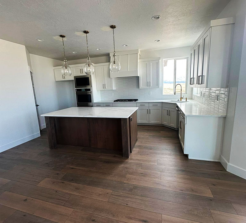 Kitchen-with-wood-floors Modern kitchen with white cabinets, wood floor, new lighting.